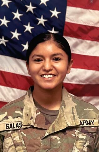 student in army uniform. The american flag is in the background